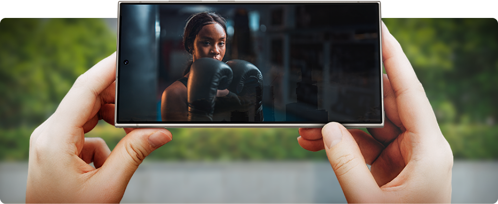 Image of person's hands holding the device on a horizontal orientation watching a video.