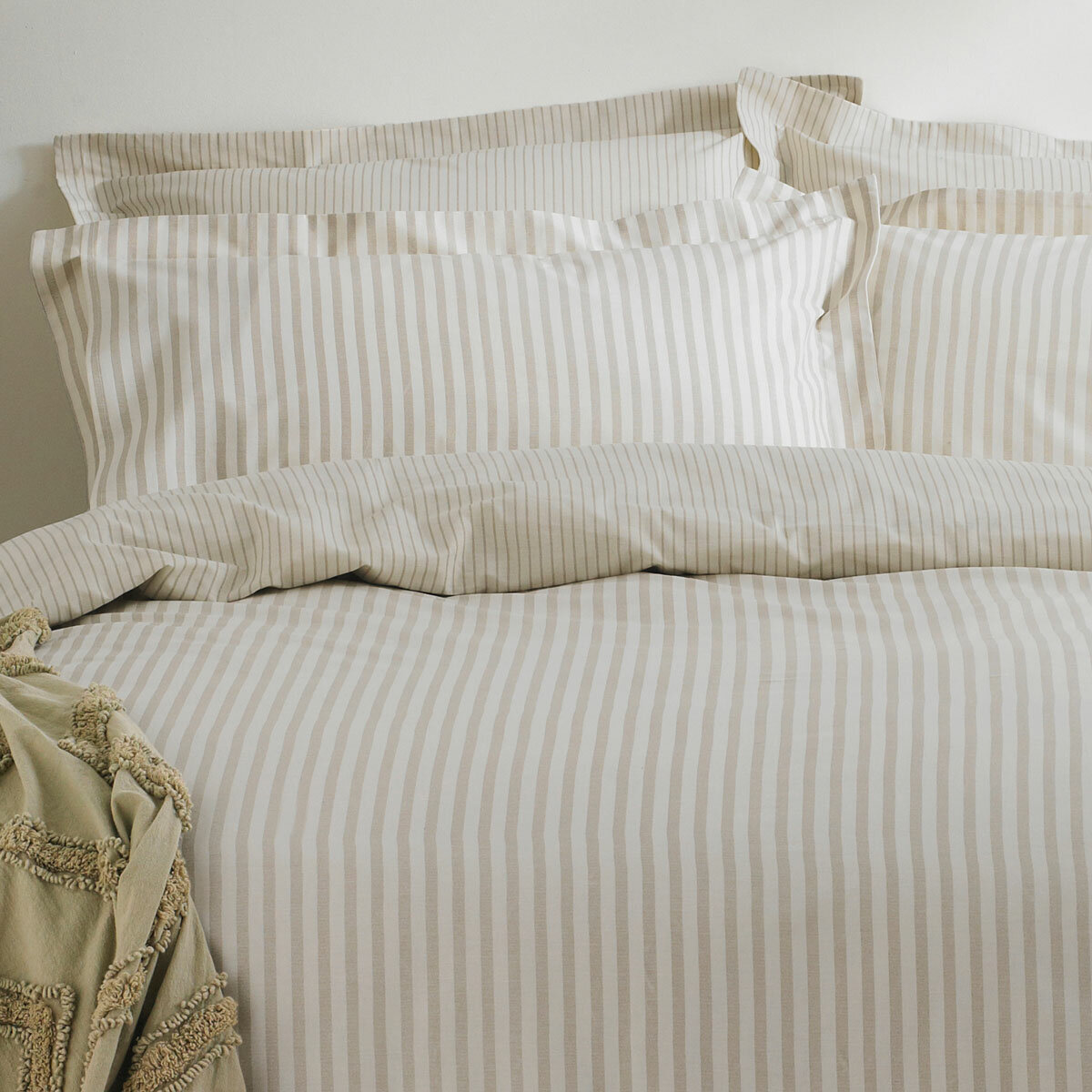 Beige and white vertically striped duvet set with matching pillowcases.