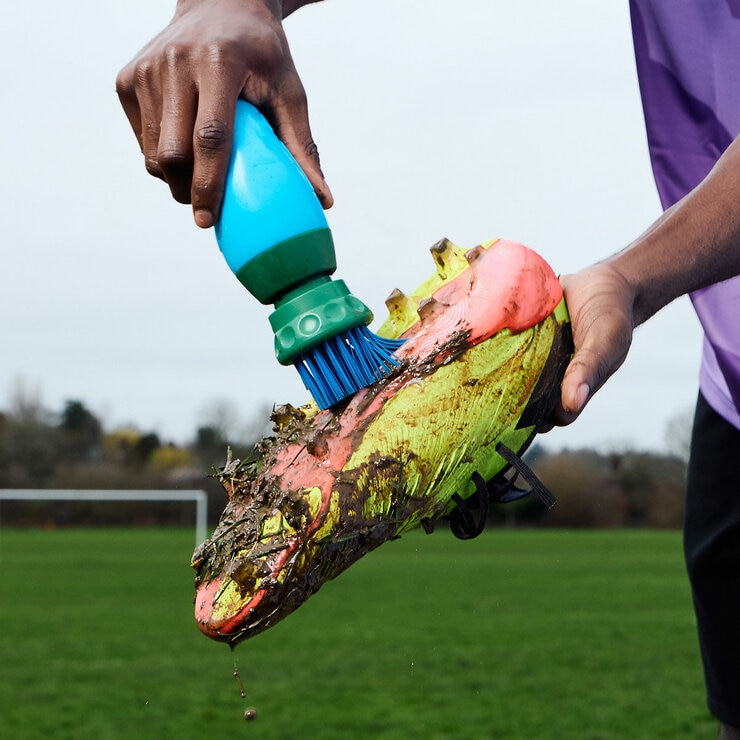Lifestyle image of someone scrubbing their shoe