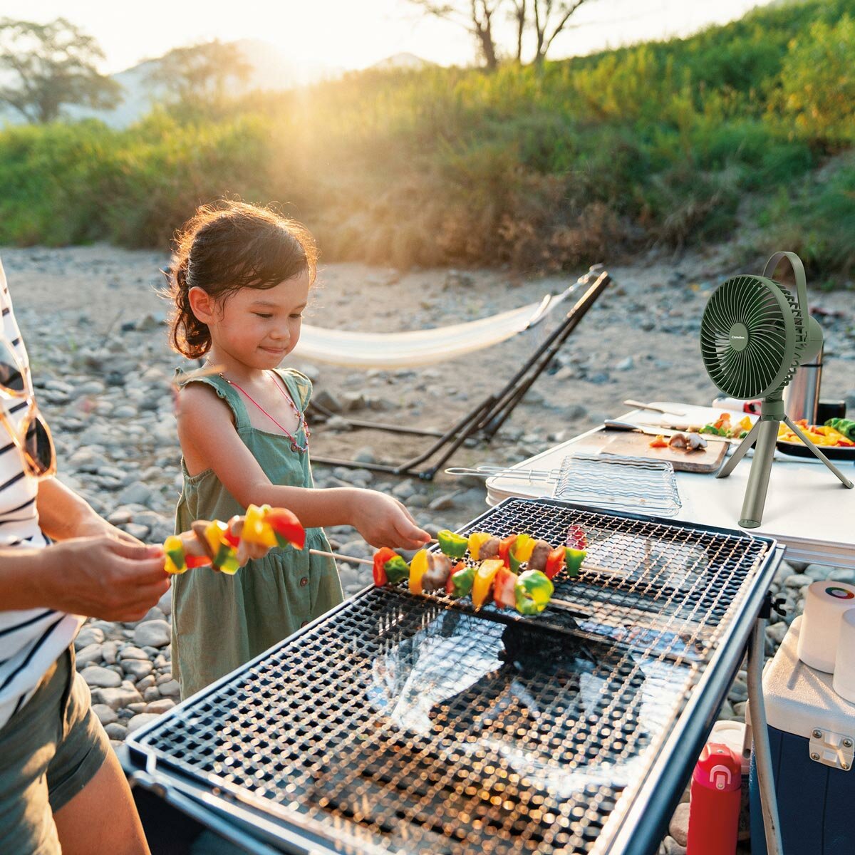 Lifestyle image showing the camping fan being used next to a barbeque Lifestyle image showing the camping fan being used next to a barbeque