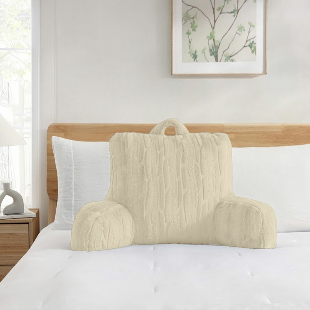 Embossed faux fur bed rest pillow in Cream, in a lifestyle image on bed.