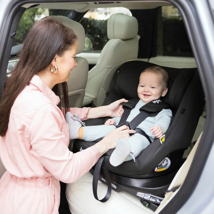 Lifestyle image of a mother putting child into the car Lifestyle image of a mother putting child into the car
