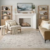 Beige rug with symmetrical floral and geometric pattern in muted blue, red, yellow, and grey