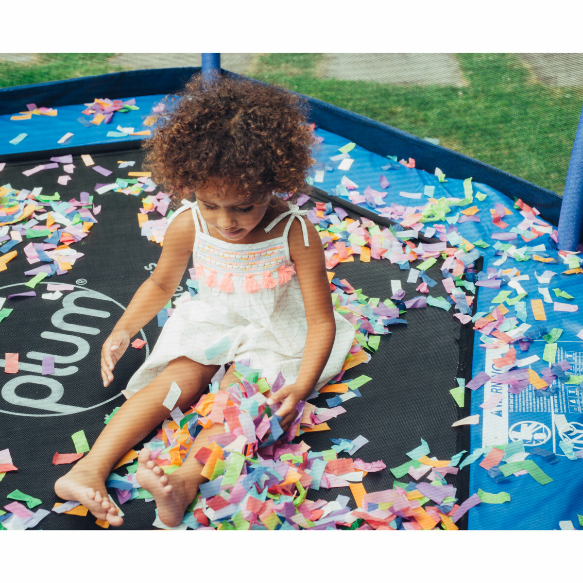 Lifestyle image of a child sat on the trampoline