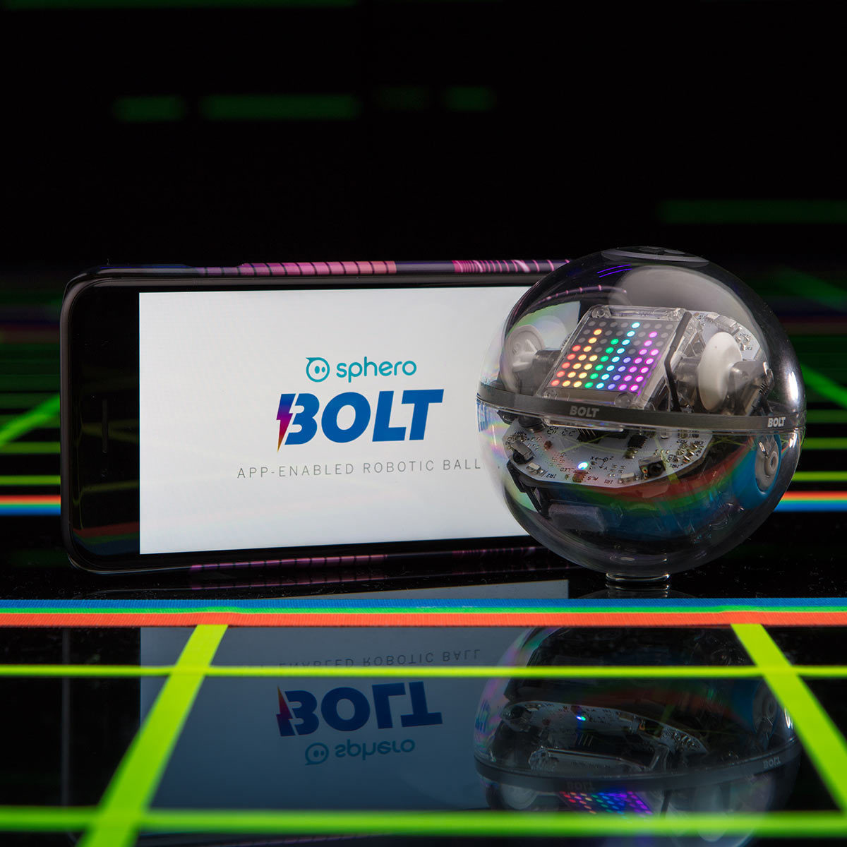 Front image of the sphero BOLT electronic interactive toy robot on a black background with neon lights and a phone displaying the app which can be used with this.