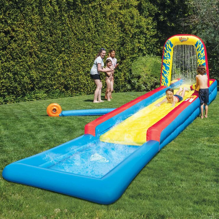 Lifestyle image of a child sliding while another child uses the water canon