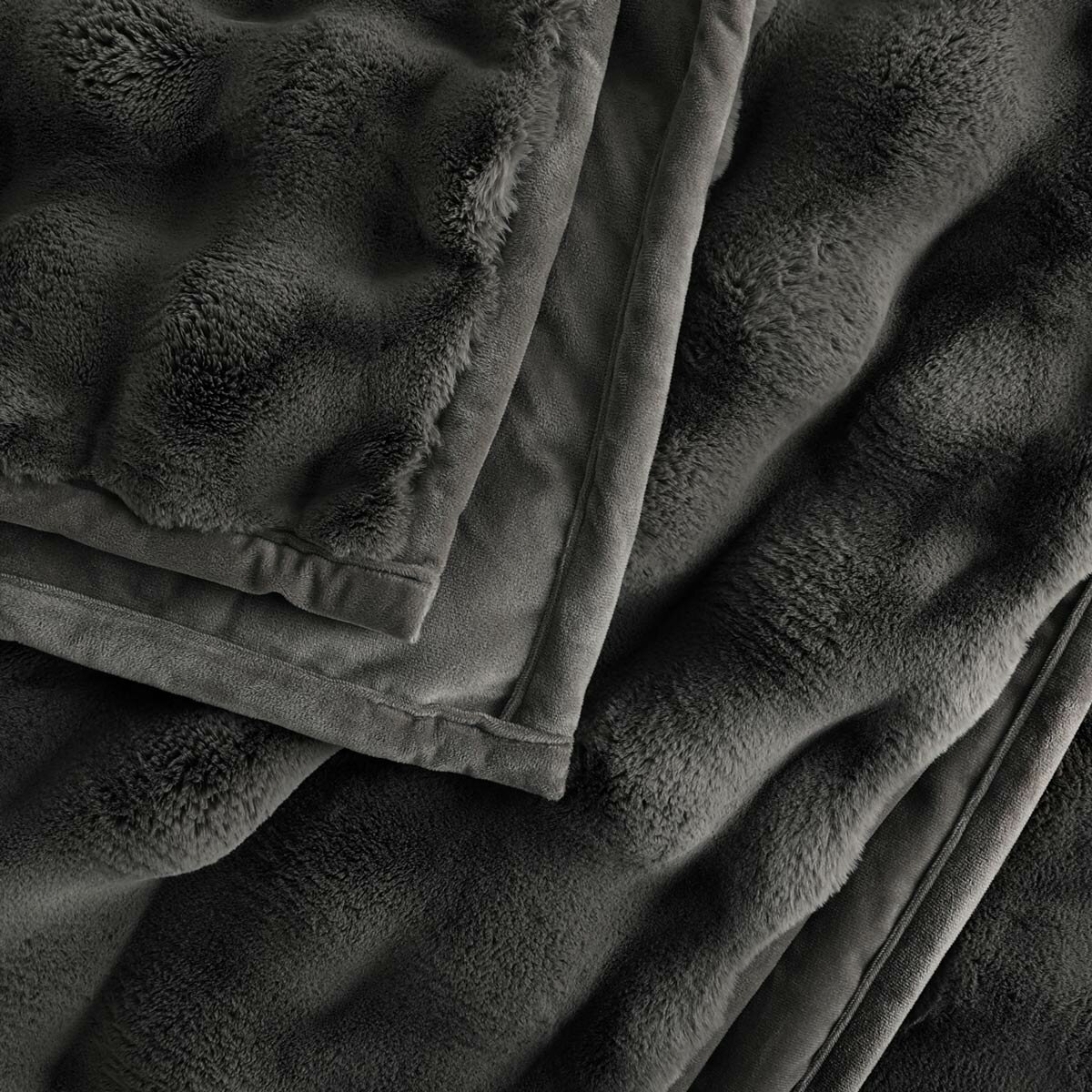 Close-up of dark grey throw with velvety surface and neatly hemmed edge