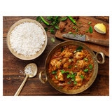 Rice in a Bowl on a Table Next to a Curry