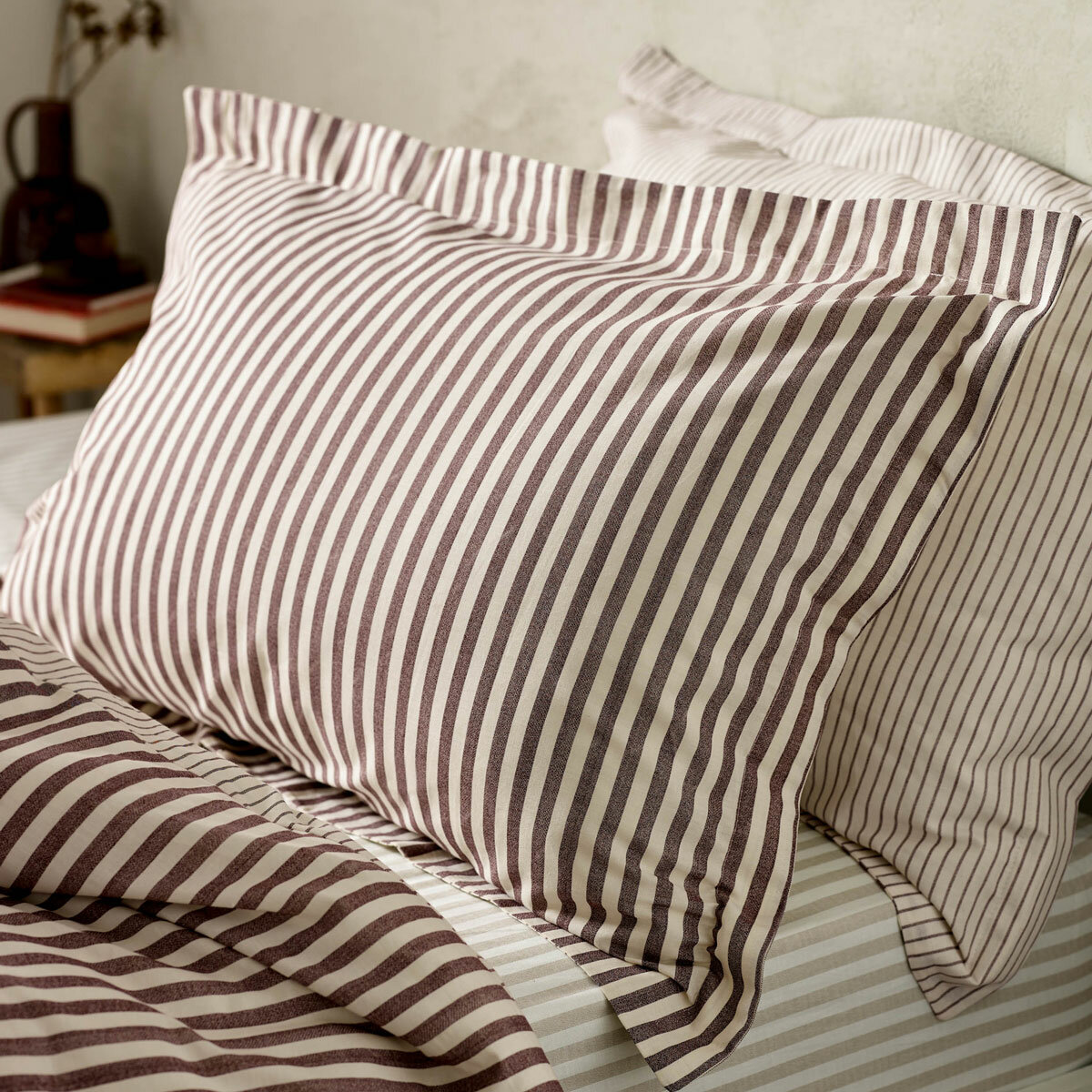 Striped duvet set with vertical burgundy and white lines, paired with matching pillowcases