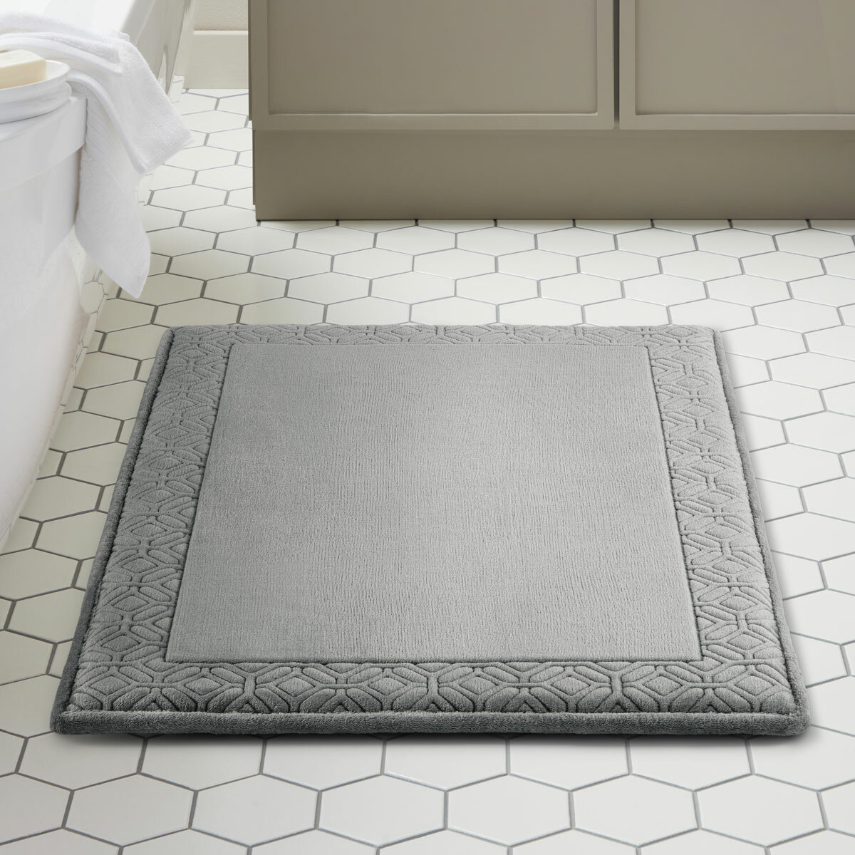 Grey bath mat styled in a modern bathroom