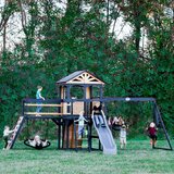 Lifestyle image of children playing on the Backyard Discovery Timber Crossing Wooden Playcentre and Swing Set