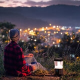 Lifestyle image of someone sat next the lantern overlooking a city