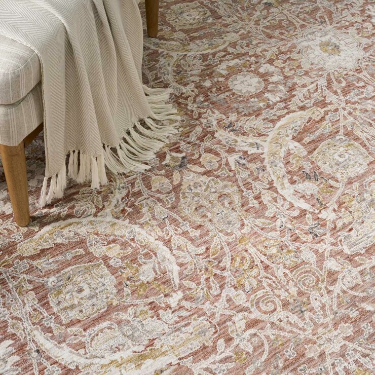 Pink and beige patterned rug with vintage-style floral and geometric motifs