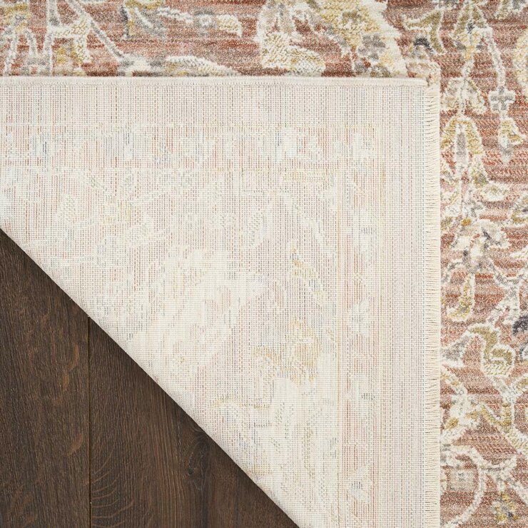 Pink and beige patterned rug with vintage-style floral and geometric motifs