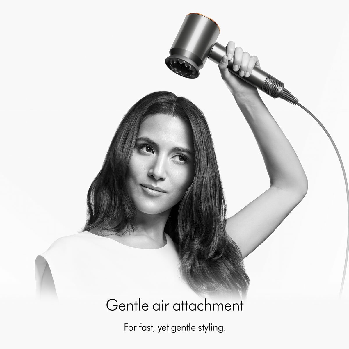 Lifestyle image of a model using Dyson Supersonic Hair Dryer's gentle air attachment