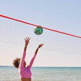 Lifestyle image of someone playing volleyball on a beach