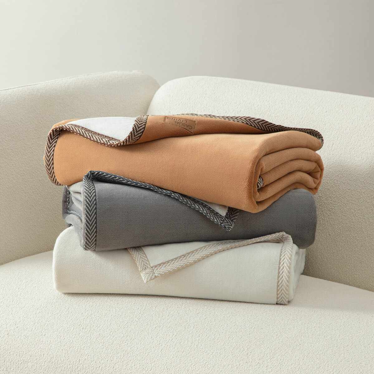 Ivory, camel and grey throw folded on sofa