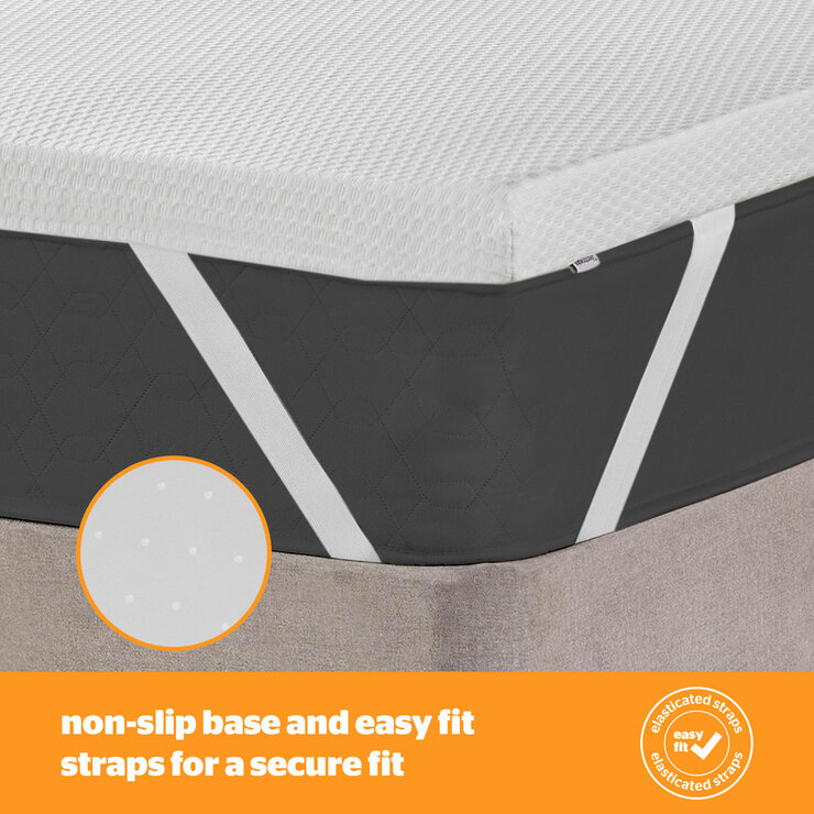 A white mattress topper with elastic corner straps fitted neatly over a mattress.