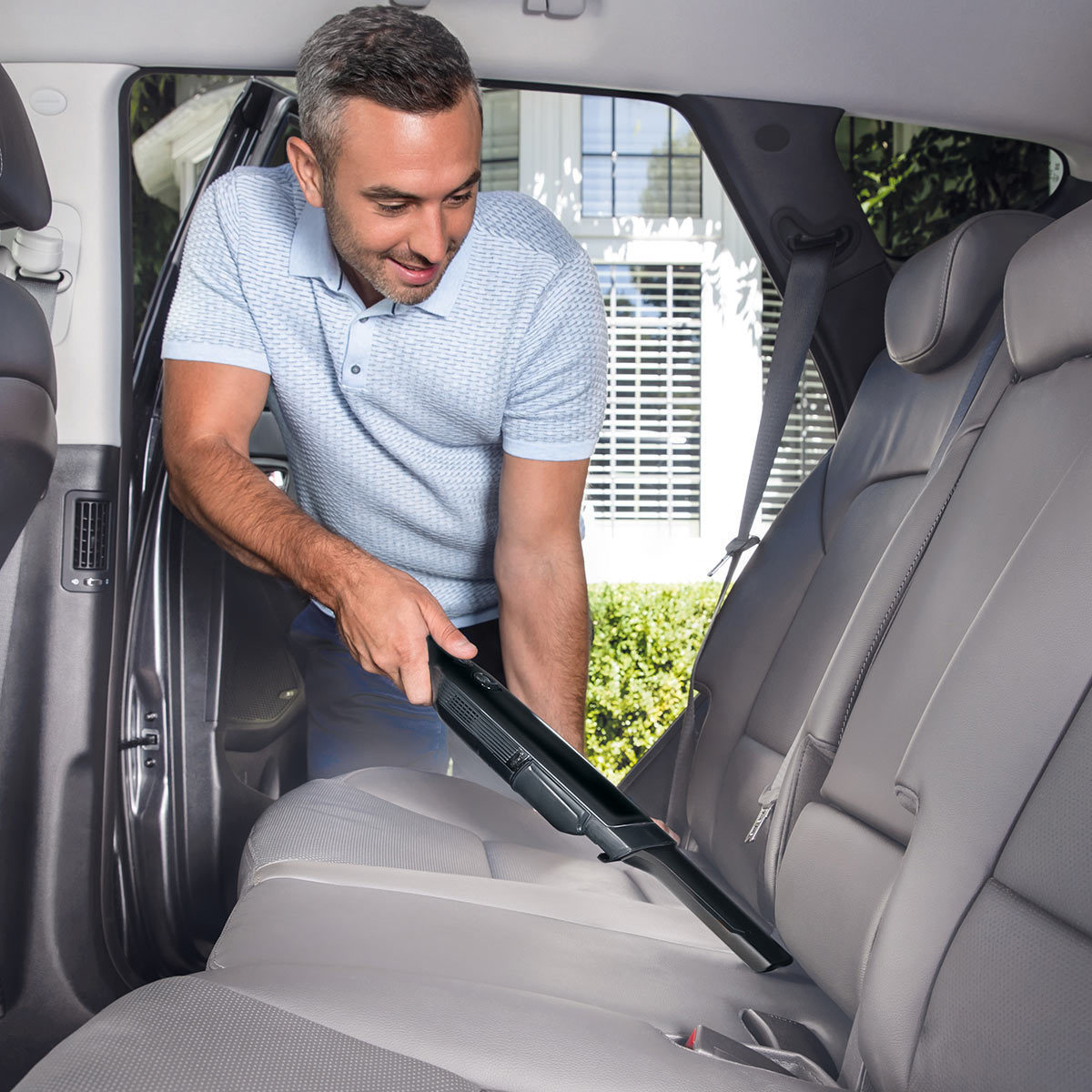 Image of man cleaning the inside of his car