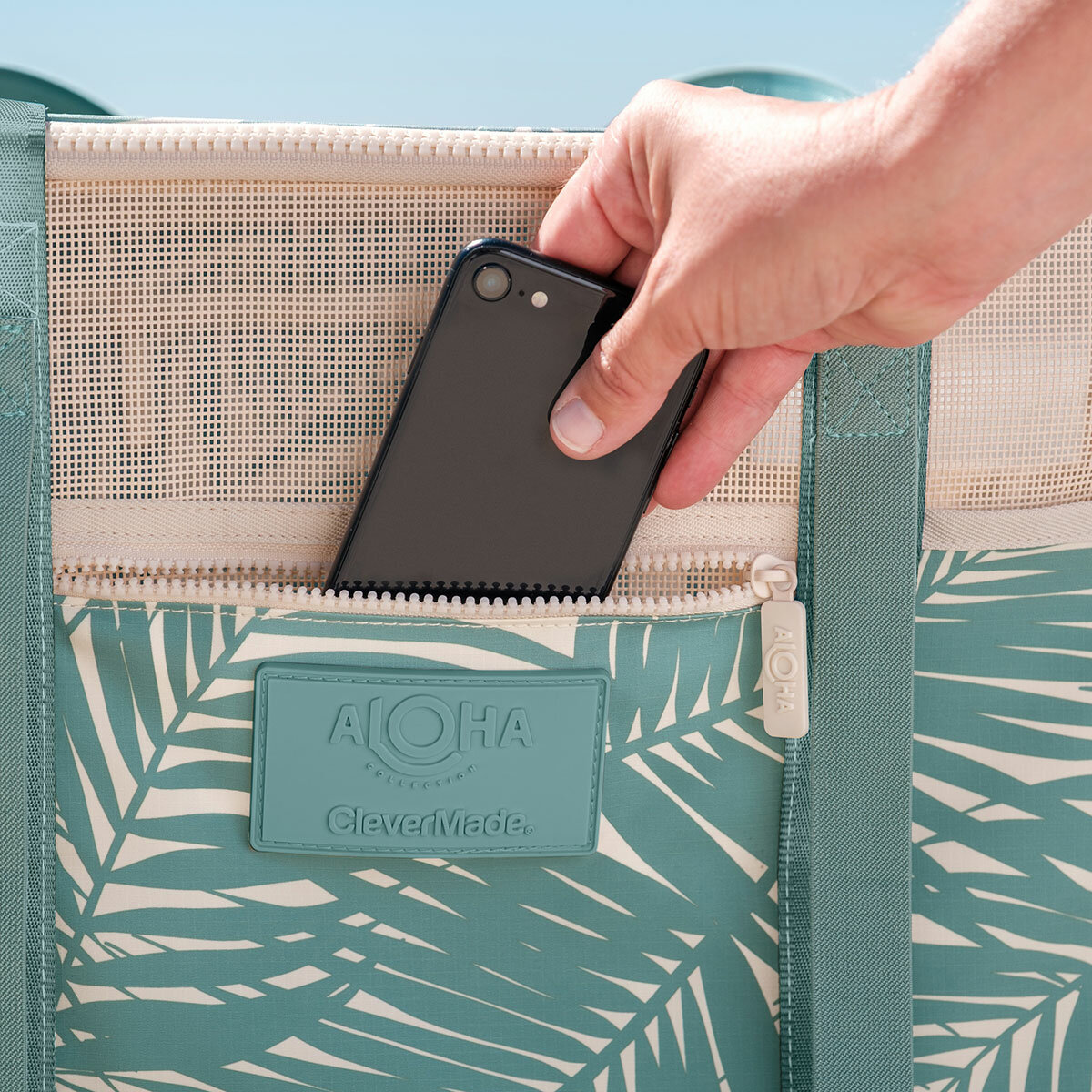 Lifestyle image of someone putting their phone into the zip pocket Lifestyle image of someone putting their phone into the zip pocket