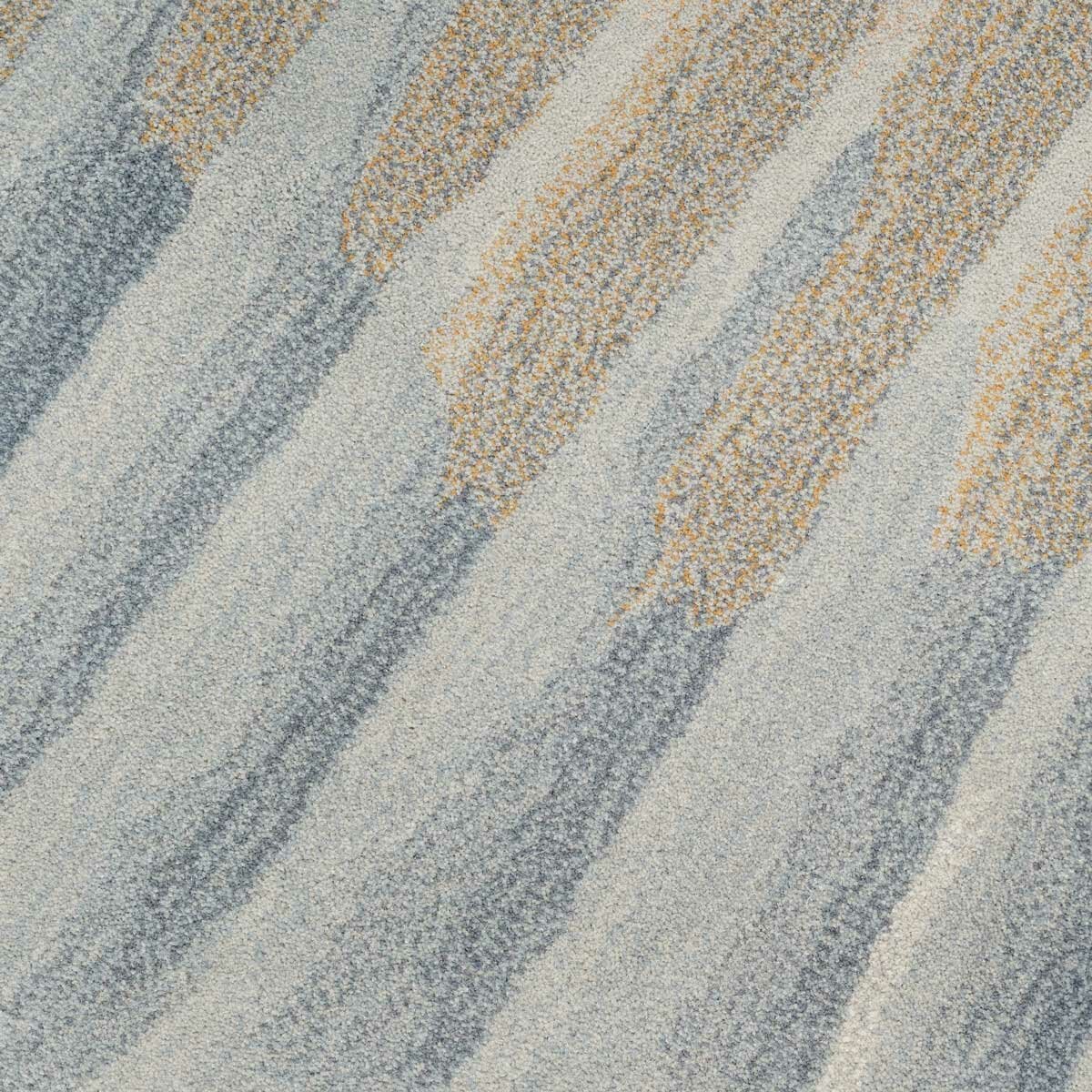 Rug with a sand-like texture and wavy bands in light blue, grey and beige, creating a dynamic, brushstroke-style pattern.