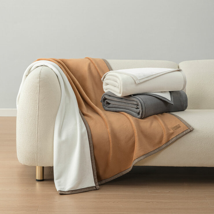 Ivory and grey throw folded on sofa with camel laid open showcasing size Ivory and grey throw folded on sofa with camel laid open showcasing size