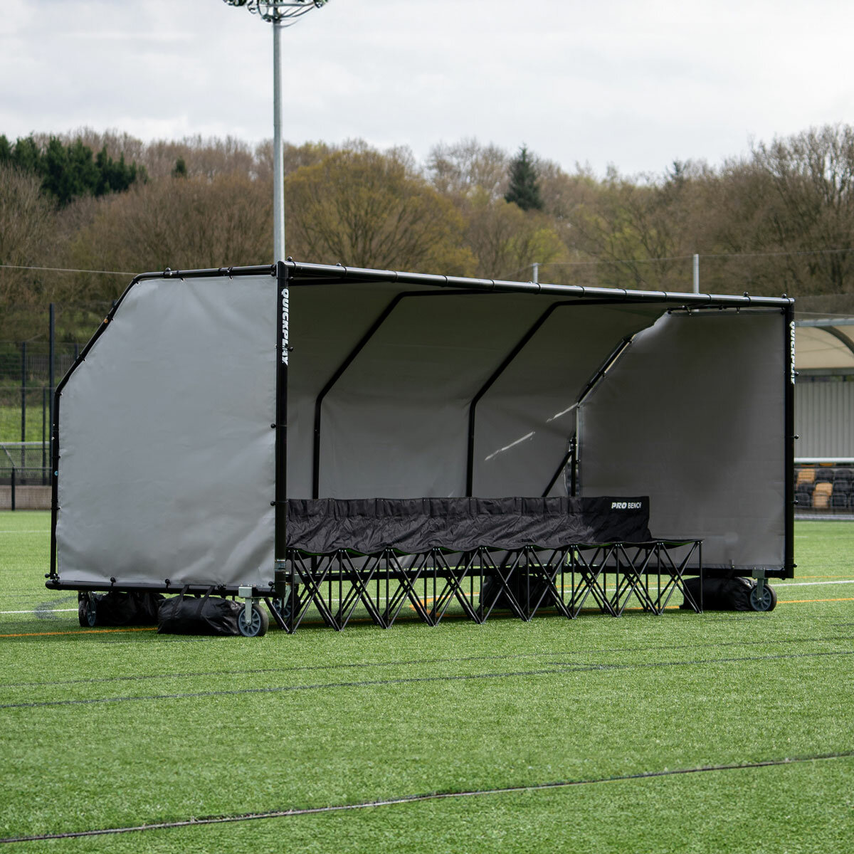 Lifestyle image of the Quickplay Pro Alu Club Shelter 16 x 6ft with chairs underneath (not included)