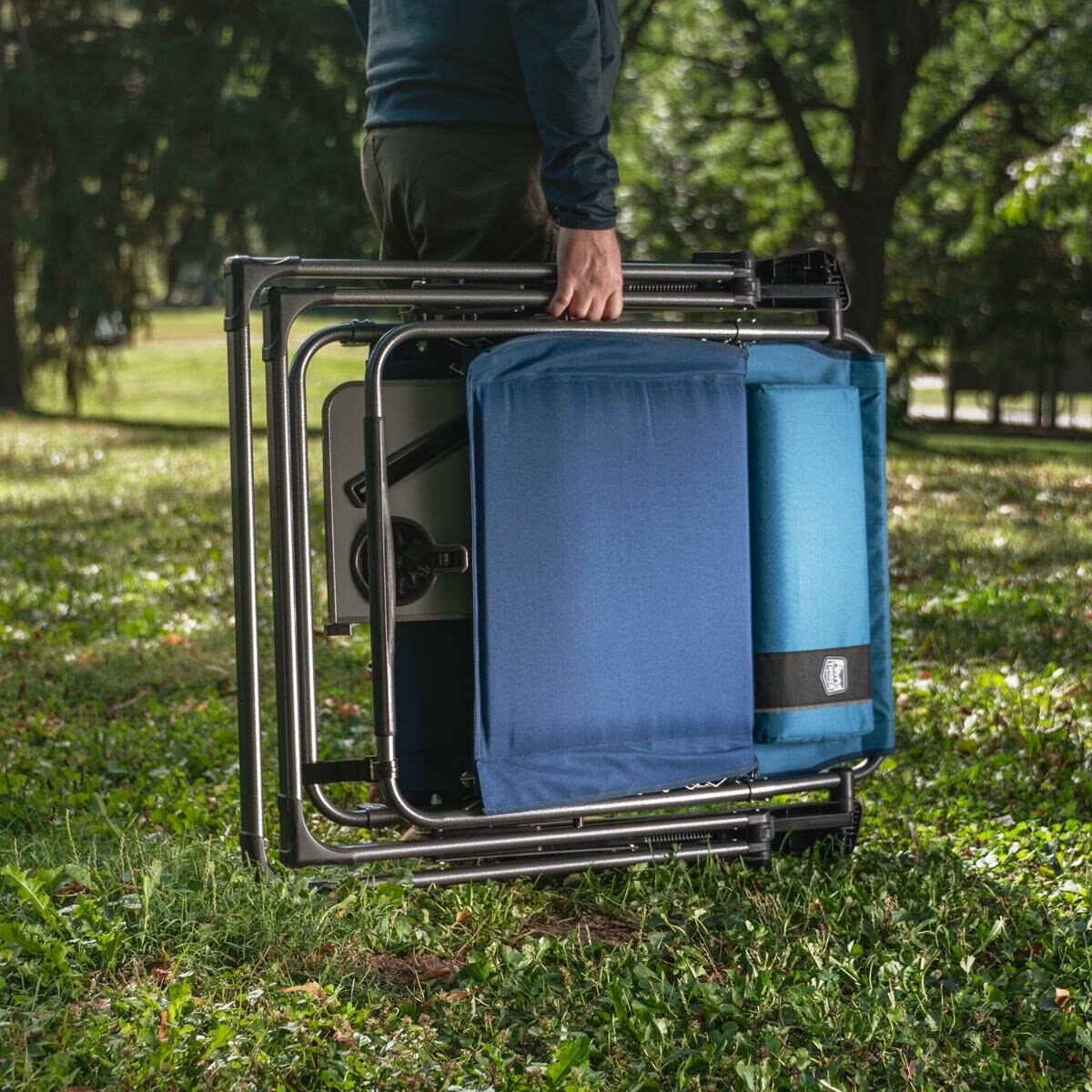 Lifestyle image of the Zero Gravity Lounger , folded and being carried Lifestyle image of the Zero Gravity Lounger , folded and being carried