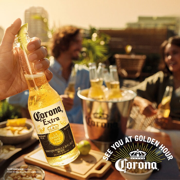 Corona Extra with a lime in the top and a bbq behind