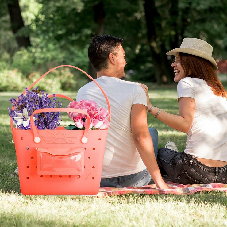 Lifestyle image of coral Beachcomber bag full of flowers