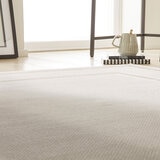 Light beige rug with subtle central pattern and layered rectangular borders, featuring a faint diamond texture on the outer edge.