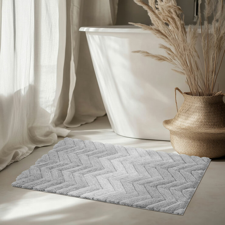Textured bath mat placed in front of white bathtu