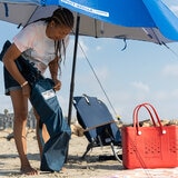 Lifestyle image of someone storing the beach chair in the included bag Lifestyle image of someone storing the beach chair in the included bag