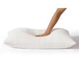 White pillow, showcasing firmness and softeness with a hand pushing pillow down