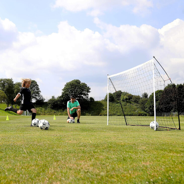 Lifestyle image of a child kicking balls into the goal