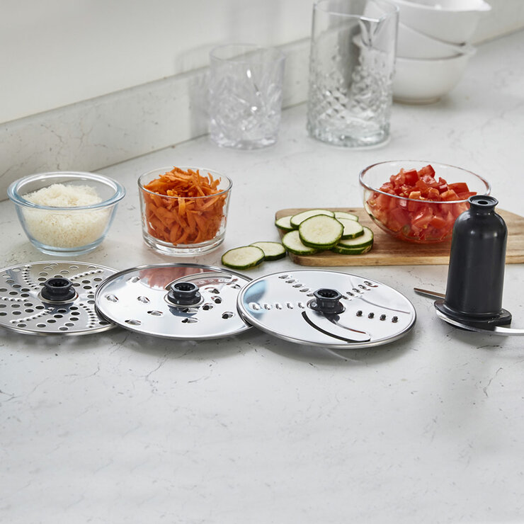 Lifestyle image of Kenwood Multipro Compact Plus Food Processor showing all the blades