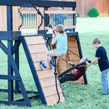 Lifestyle image of a child climbing the wall, and two children using the web swing