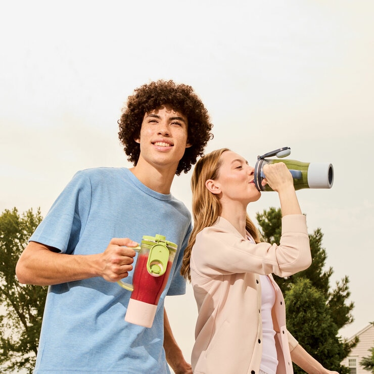Lifestyle image of model drinking from Ninja BlendBoss 710ml Travel Tumbler