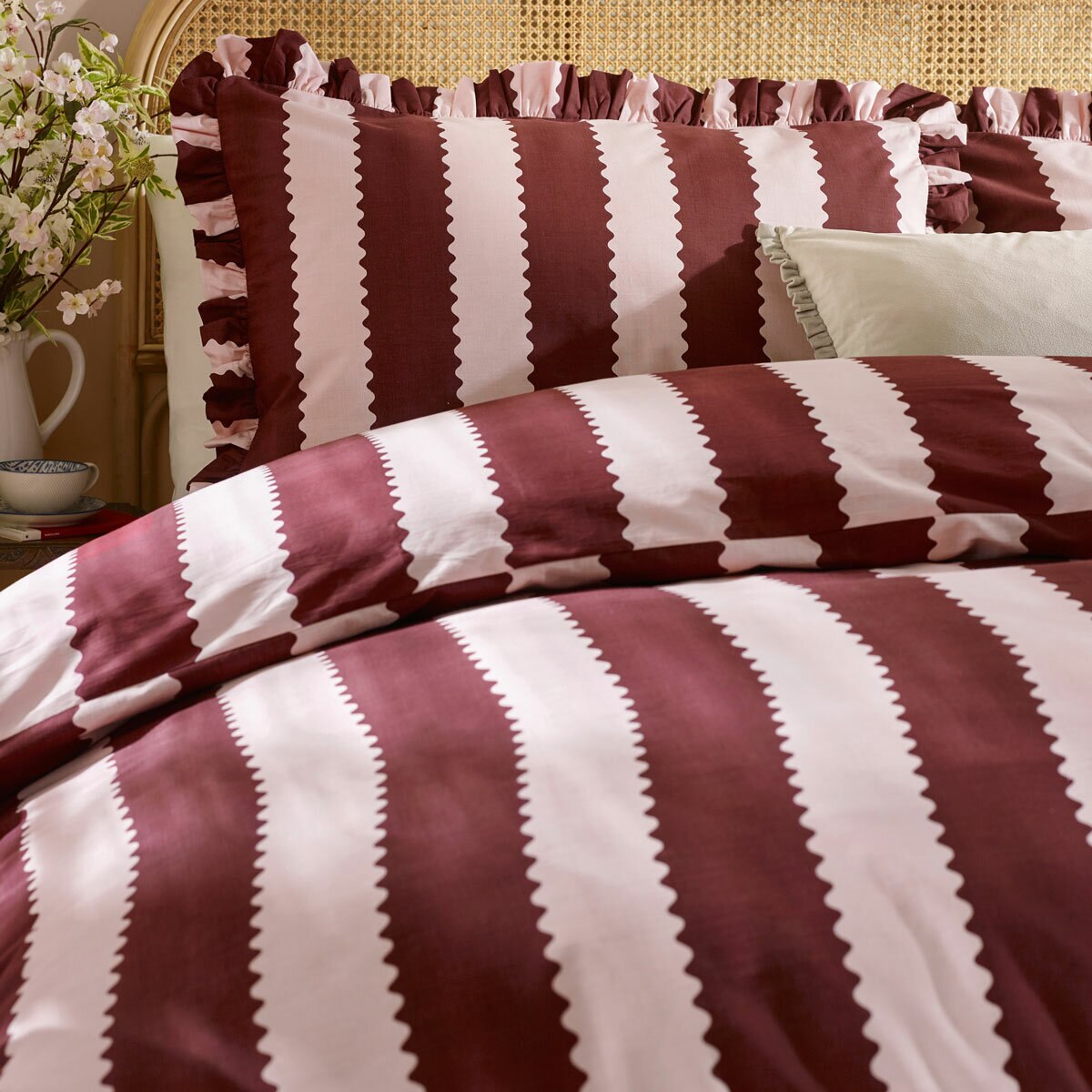 Burgundy and white vertically striped duvet set with ruffled edges and matching pillowcases Burgundy and white vertically striped duvet set with ruffled edges and matching pillowcases