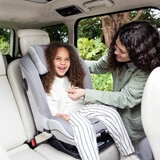 Lifestyle image of a woman buckling a child into the car seat
