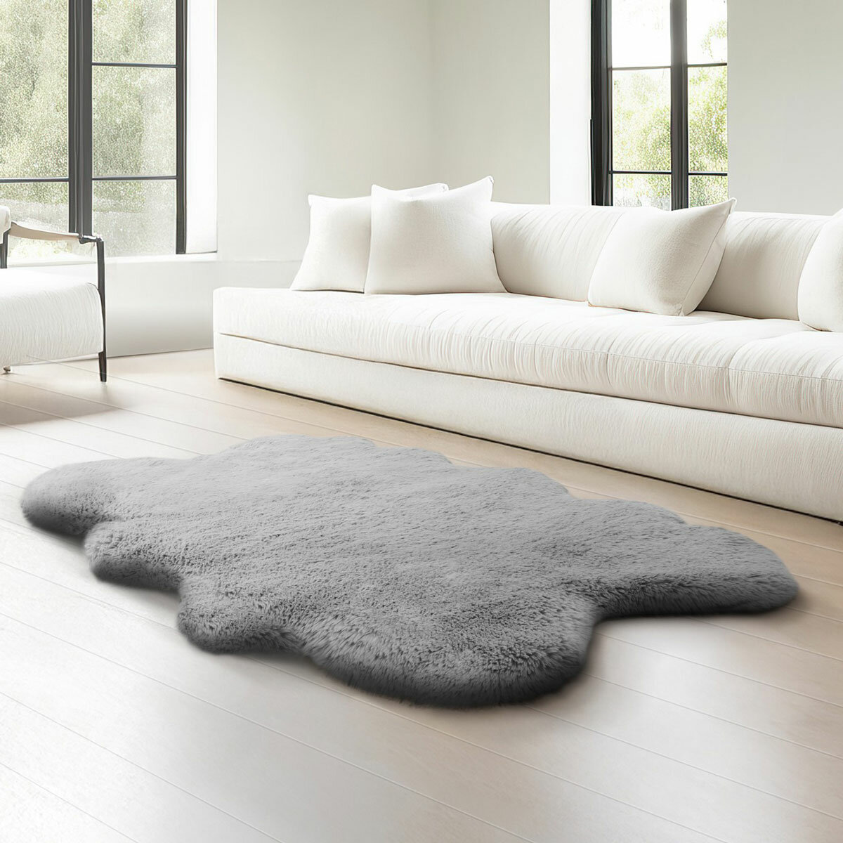 Grey faux fur quad rug in a living room, styled next to sofa