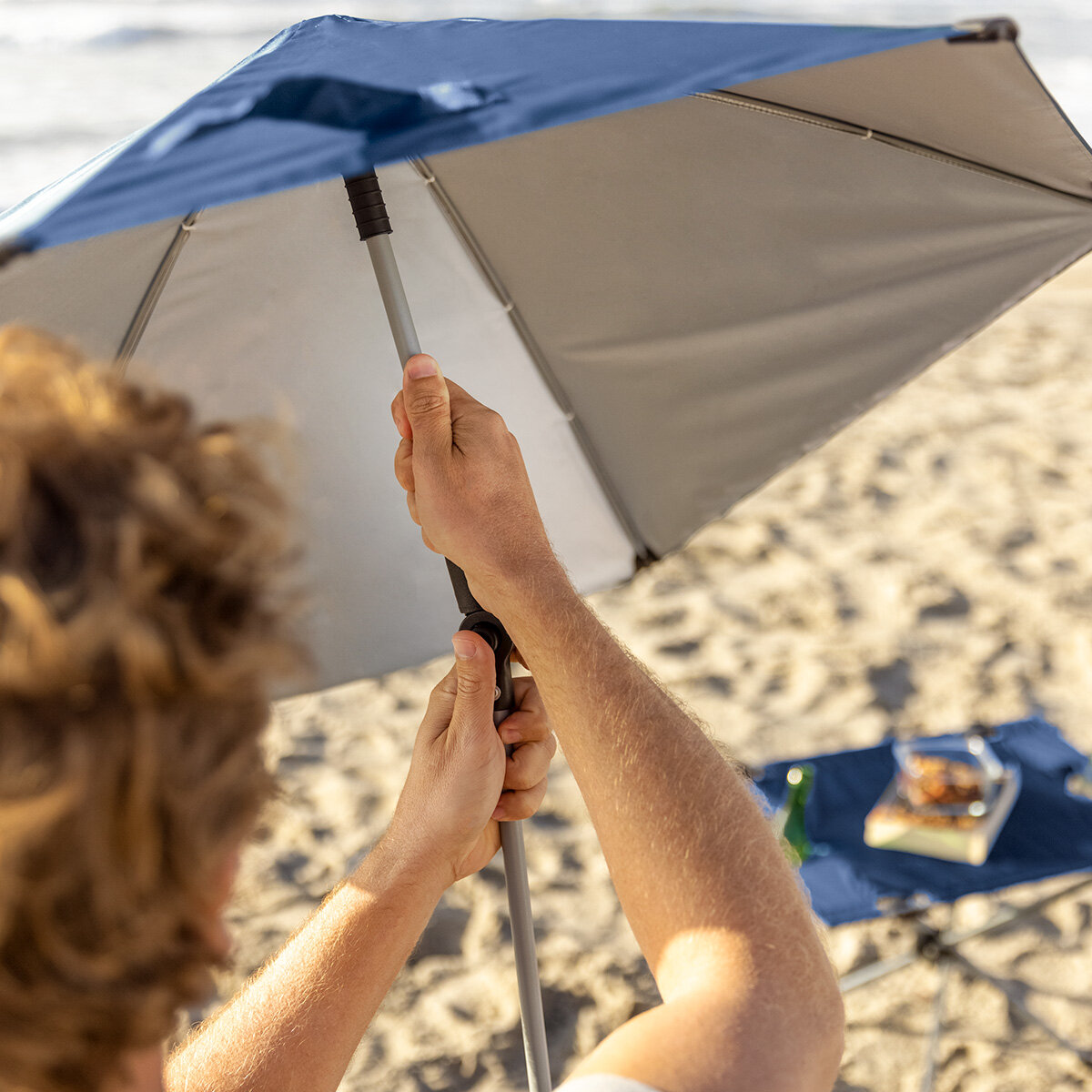Lifestyle image of someone adjusting the umbrella Lifestyle image of someone adjusting the umbrella