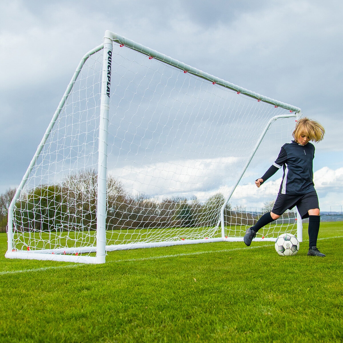 Lifestyle image of a goalkeeper kicking a football away from the goal