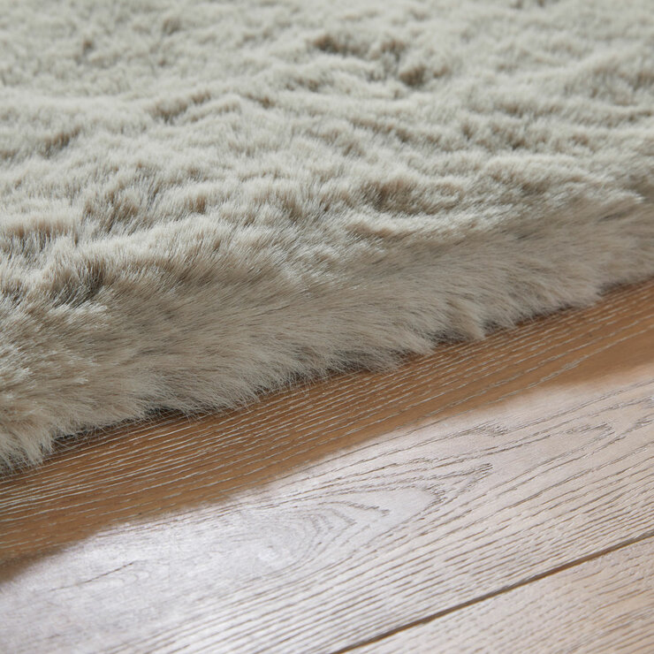 taupe faux fur rug with thick, fluffy texture on wooden floor taupe faux fur rug with thick, fluffy texture on wooden floor