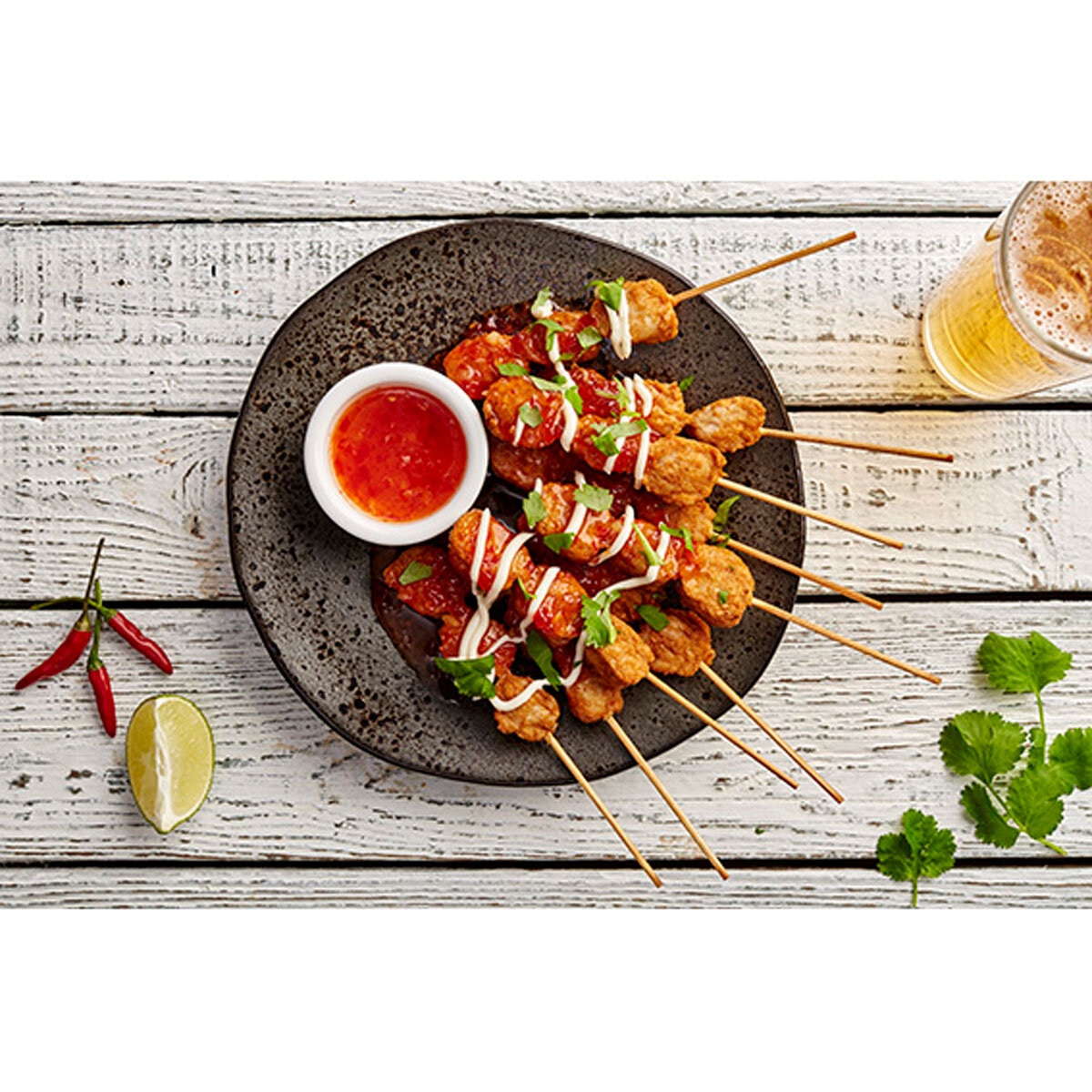 Chicken Satay sticks laid out on a plate with garnish