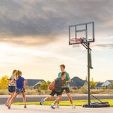 Lifestyle image of four people playing basketball with the 52 inch basketball hoop in the background Lifestyle image of four people playing basketball with the 52 inch basketball hoop in the background
