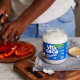 Lifestyle shot of open jar of coconut oil and chopping board