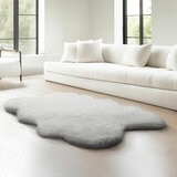 Ivory faux fur quad rug in a living room, styled next to sofa