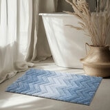Textured bath mat placed in front of white bathtu