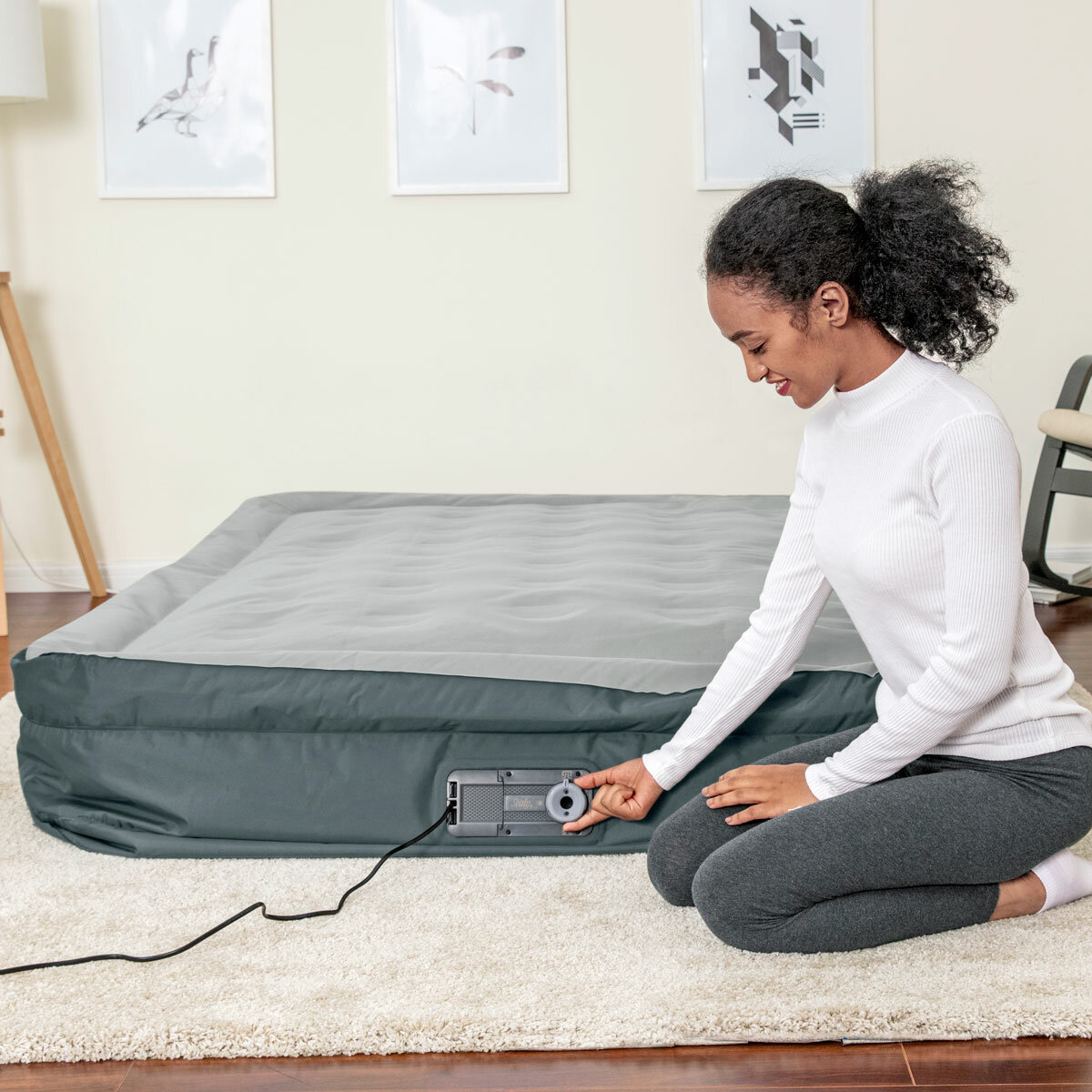 Lifestyle image of a woman deflating the airbed Lifestyle image of a woman deflating the airbed